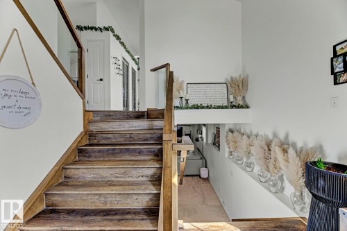 Wood-finish staircase with clear panel railing and wood banister - 3208 135A Avenue, Edmonton, AB - Indoor Photo Showing Other Room