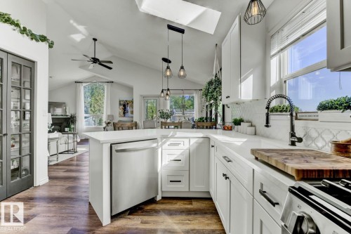 Modern kitchen featuring white cabinetry, a stainless steel dishwasher, and a black gooseneck faucet - 3208 135A Avenue, Edmonton, AB - Indoor Photo Showing Kitchen
