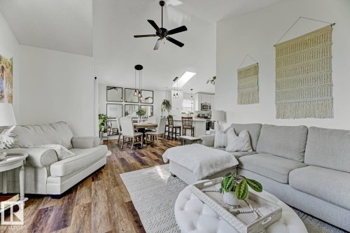 Open-concept living space featuring vaulted ceilings, wood-finish flooring, a ceiling fan, a dining area with pendant lighting, and a kitchen with a skylight - 3208 135A Avenue, Edmonton, AB - Indoor Photo Showing Living Room
