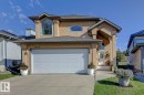 Stucco exterior residence featuring an integrated two-car garage, prominent arched entry with recessed porch, and upper-level arched and bay windows - 3208 135A Avenue, Edmonton, AB  - Outdoor 