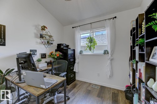 Dedicated room featuring wood-finish flooring and a window with white trim - 3208 135A Avenue, Edmonton, AB - Indoor Photo Showing Other Room