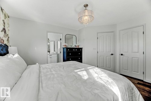 Bedroom featuring wood-finish flooring and a decorative chandelier - 3208 135A Avenue, Edmonton, AB - Indoor Photo Showing Bedroom