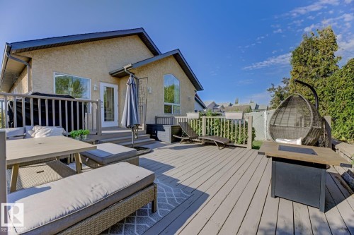 Expansive elevated deck featuring a light gray wood-finish surface, perimeter railing, and direct exterior access - 3208 135A Avenue, Edmonton, AB - Outdoor With Deck Patio Veranda With Exterior