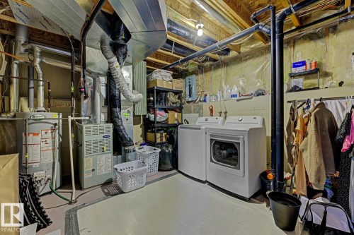 Dedicated utility area featuring a water heater, furnace, and washer and dryer units - 3208 135A Avenue, Edmonton, AB - Indoor Photo Showing Laundry Room
