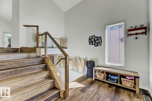 Staircase featuring wood-finish treads and risers, glass panel railings, and a wood handrail - 3208 135A Avenue, Edmonton, AB - Indoor Photo Showing Other Room
