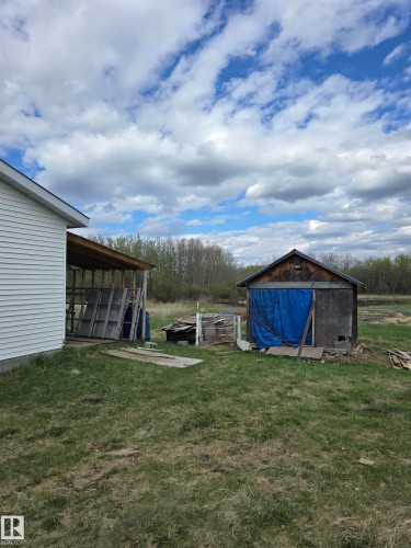 Outbuilding with wood siding and a covered storage area - 53559 Range Rd 220, Rural Strathcona County, AB - Outdoor