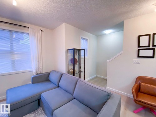 Living area featuring light-tone walls, recessed lighting, and wood-finish flooring - 118 655 Watt Boulevard, Edmonton, AB - Indoor
