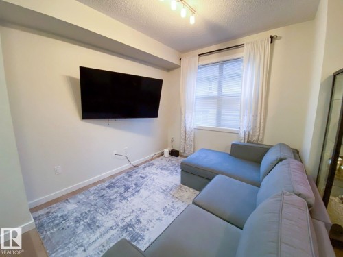 Recessed window with blinds, light-toned walls, and track lighting - 118 655 Watt Boulevard, Edmonton, AB - Indoor Photo Showing Living Room