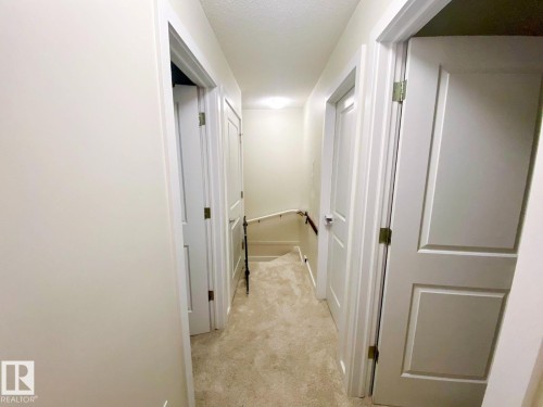 Carpeted hallway with light neutral walls and white trim - 118 655 Watt Boulevard, Edmonton, AB - Indoor Photo Showing Other Room