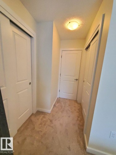 Neutral tone carpeting with white baseboards and trim - 118 655 Watt Boulevard, Edmonton, AB - Indoor Photo Showing Other Room