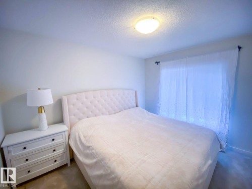 Bedroom featuring light-toned walls, a flush-mount ceiling light, and carpet flooring - 118 655 Watt Boulevard, Edmonton, AB - Indoor Photo Showing Bedroom