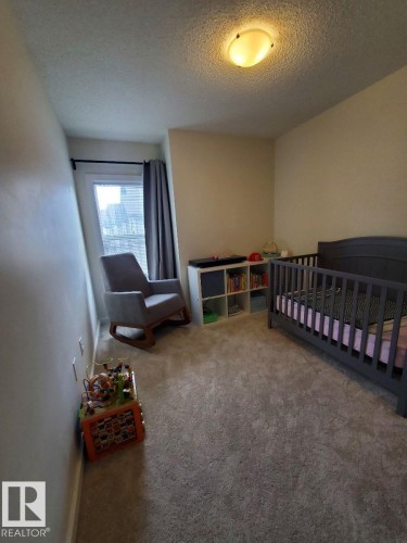 Carpeted room with neutral wall tones and a window with drapery - 118 655 Watt Boulevard, Edmonton, AB - Indoor Photo Showing Bedroom
