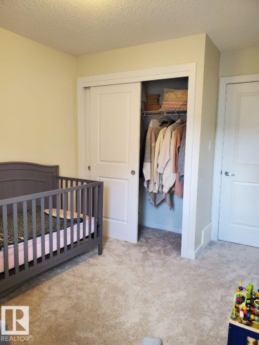 Recessed lighting illuminates a space featuring a closet with bi-fold doors, wire shelving, and plush carpet flooring - 118 655 Watt Boulevard, Edmonton, AB - Indoor Photo Showing Bedroom
