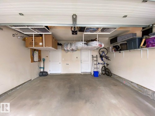 Spacious garage featuring concrete flooring, white walls, and overhead garage door - 118 655 Watt Boulevard, Edmonton, AB - Indoor Photo Showing Garage