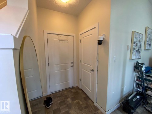 Entryway featuring two white panel doors, neutral wall tones, and patterned flooring - 118 655 Watt Boulevard, Edmonton, AB - Indoor Photo Showing Other Room