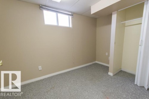 This room features light-colored walls, a window with blinds, and gray speckled carpeting - 10806 64 Avenue, Edmonton, AB - Indoor