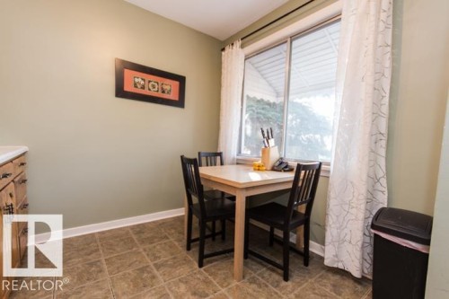 This dining area features a large window with sheer patterned curtains, offering natural light - 10806 64 Avenue, Edmonton, AB - Indoor Photo Showing Dining Room