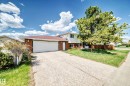 Brick and siding exterior featuring an attached garage, paved driveway, mature trees, and a red shingle roof - 1804 51 Street Nw, Edmonton, AB  - Outdoor 