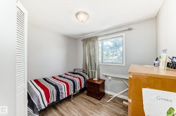 Room featuring wood-finish flooring, a window with exterior views, and a louvered bi-fold closet door - 