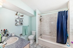Bathroom featuring a white bathtub, ceramic tile shower surround, and a vanity with a drop-in sink and laminate countertop - 