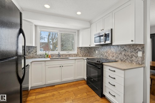 The kitchen features white cabinetry, a tiled backsplash, and stainless steel appliances - 17 Austin Crescent, St. Albert, AB - Indoor Photo Showing Kitchen With Upgraded Kitchen