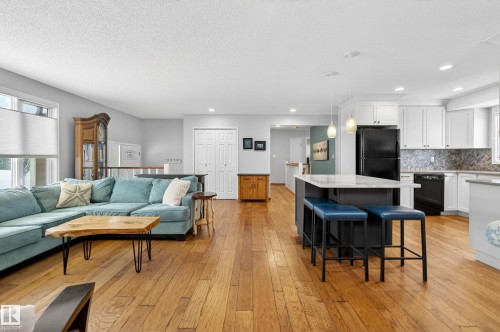 This inviting open-concept living space features hardwood floors throughout - 17 Austin Crescent, St. Albert, AB - Indoor Photo Showing Living Room