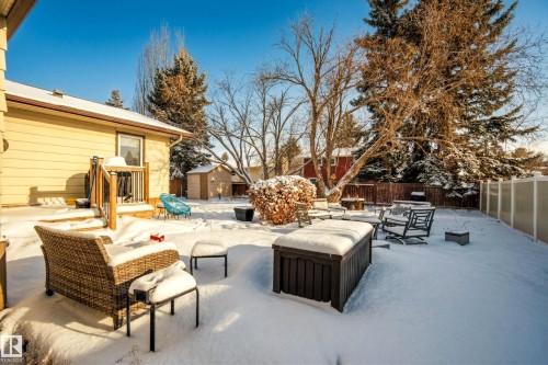 The property features an extensive backyard, complete with a wooden deck and a storage shed, enclosed by a privacy fence - 17 Austin Crescent, St. Albert, AB - Outdoor With Deck Patio Veranda