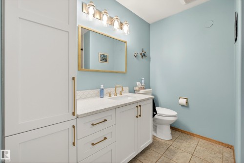 Well-appointed bathroom featuring a vanity with a white countertop and white cabinetry, a gold-framed mirror, and tiled flooring - 17 Austin Crescent, St. Albert, AB - Indoor Photo Showing Bathroom