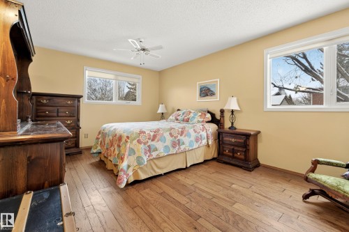 This room features hardwood flooring, two windows providing natural light, and a ceiling fan - 17 Austin Crescent, St. Albert, AB - Indoor Photo Showing Bedroom