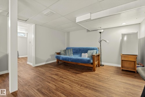 This versatile room features warm wood-style flooring and light-colored walls, creating an inviting atmosphere - 17 Austin Crescent, St. Albert, AB - Indoor