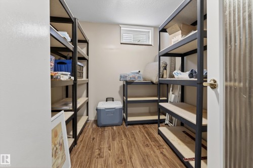 Well-organized utility room featuring a window for natural light, durable flooring, and extensive shelving for optimal storage - 17 Austin Crescent, St. Albert, AB - Indoor