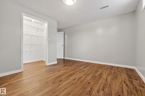 Room featuring wood-look flooring, light gray walls, and a white ceiling with a flush-mount light fixture - 17 Austin Crescent, St. Albert, AB - Indoor Photo Showing Other Room