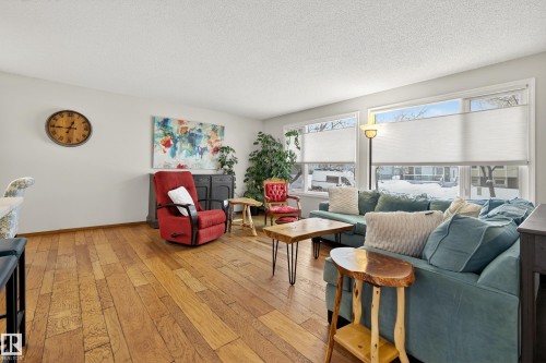 The living area features hardwood floors and large windows providing natural light - 17 Austin Crescent, St. Albert, AB - Indoor Photo Showing Living Room