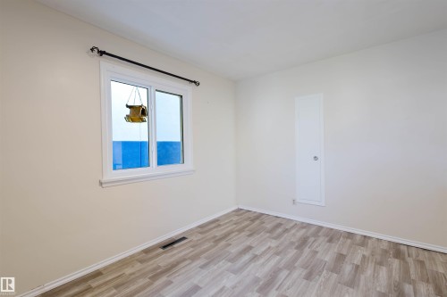Light-colored walls complement the wood-finish flooring - 10511 80 Street, Edmonton, AB - Indoor Photo Showing Other Room