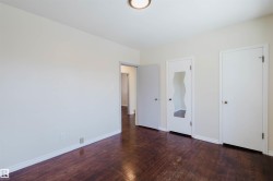 Interior space featuring wood-finish flooring, white baseboards, and light-toned walls - 