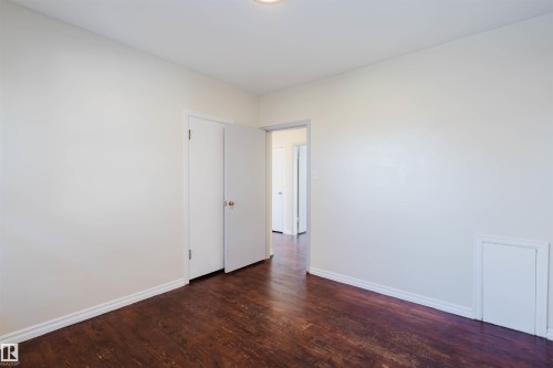 Interior room featuring wood-finish flooring, white baseboards, and light-colored walls - 10511 80 Street, Edmonton, AB - Indoor Photo Showing Other Room