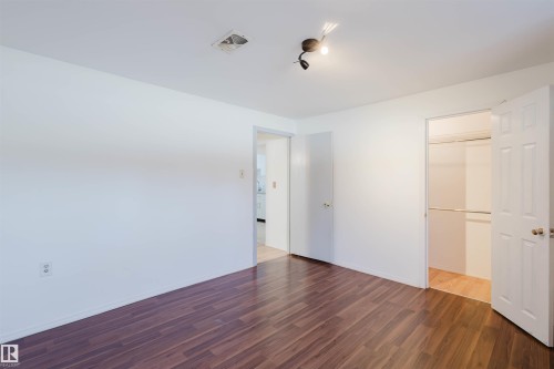 Room with dark wood-finish flooring, white walls, and a track light fixture - 10511 80 Street, Edmonton, AB - Indoor Photo Showing Other Room