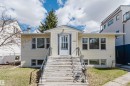 Exterior featuring light yellow siding, multiple windows, and a prominent front entrance with a storm door - 10511 80 Street, Edmonton, AB  - Outdoor 