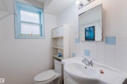 Bathroom featuring a wall-mounted sink, ceramic tile backsplash with accent squares, and a medicine cabinet with integrated lighting - 
