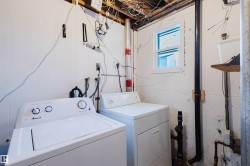 Dedicated laundry area featuring white paneled walls and a built-in window - 