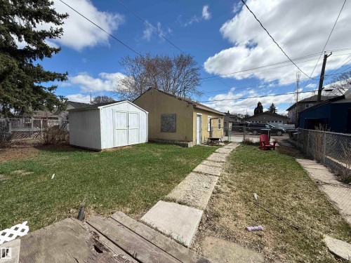 Backyard featuring a detached storage shed, chain-link fencing, and concrete paver pathway - 10511 80 Street, Edmonton, AB - Outdoor