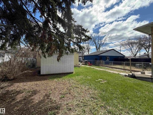 Expansive backyard featuring a green lawn, mature trees, and a functional storage shed - 10511 80 Street, Edmonton, AB - Outdoor