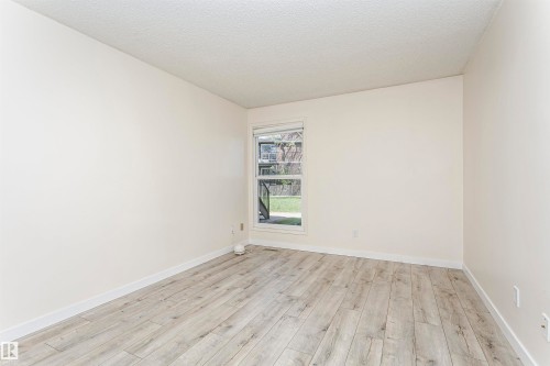 Light wood-finish flooring with white baseboards and neutral wall paint - 9221 172 Street, Edmonton, AB - Indoor Photo Showing Other Room