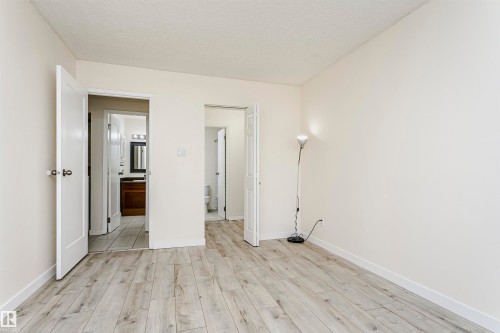Interior room featuring wood-finish flooring, white baseboards, and neutral wall tones - 9221 172 Street, Edmonton, AB - Indoor Photo Showing Other Room