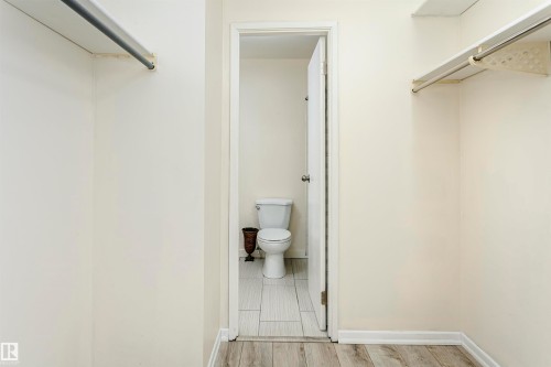 Spacious closet featuring light wood-finish flooring and multiple clothing rods - 9221 172 Street, Edmonton, AB - Indoor