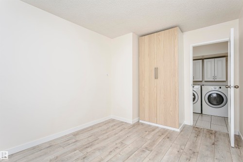 Light wood-finish flooring extending from the entryway - 9221 172 Street, Edmonton, AB - Indoor Photo Showing Laundry Room