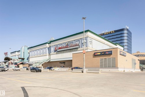 Commercial complex featuring a multi-story building with a light blue and white facade, a brown brick section, and a prominent sign - 9221 172 Street, Edmonton, AB - Outdoor