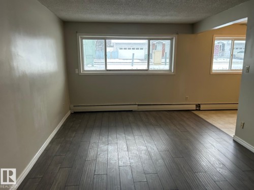 This room features wide plank flooring and a neutral color palette - 4 10164 150 Street, Edmonton, AB - Indoor Photo Showing Other Room