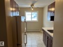 The kitchen features a window, a ceiling fan, and tiled flooring - 4 10164 150 Street, Edmonton, AB  - Indoor Photo Showing Kitchen 