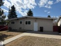 Stucco exterior featuring multiple windows and a white entrance door - 13437 118 Street, Edmonton, AB  - Outdoor 
